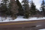 The property is located along the paved Riverside Road and features an established access road into the lot, as seen here in this wintertime photo..